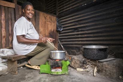 Woman sitting next to cooking pots