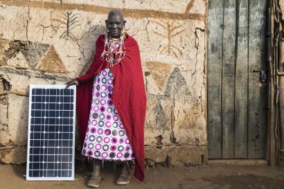 Woman standing next to solar panel