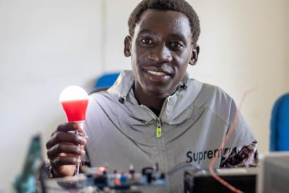 Man holding led lightbulb, smiling.