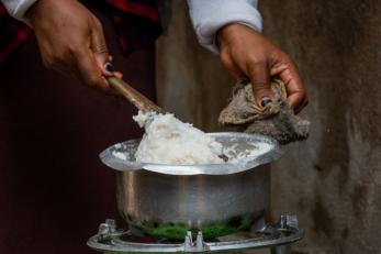 Person scooping food from pot
