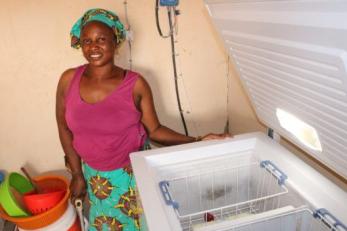 Woman standing next to open freezer