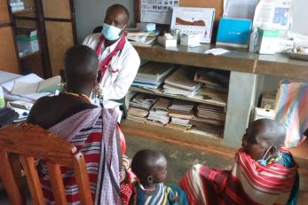 A health care provider talks with patients in a medical office