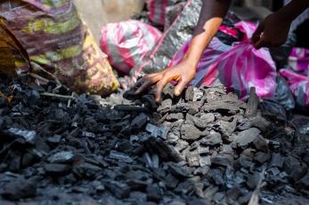 Person reaching into charcoal