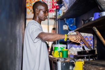 A man in a kitchen stirring a pot