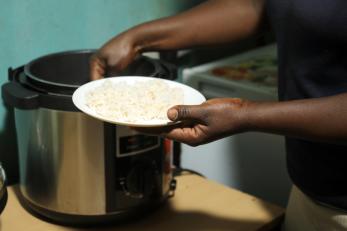 person getting food from a pot