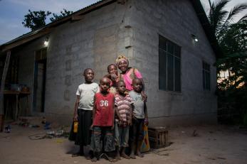 Family standing outside house with lights on
