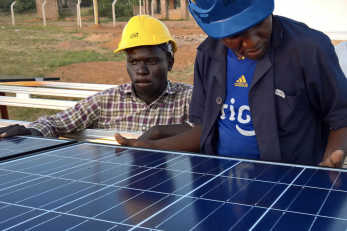 two men constructing a solar panel