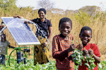 two adults and two children near solar panel