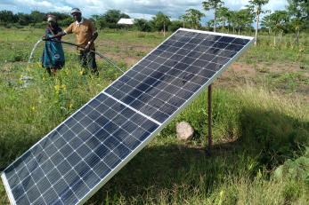two people in farm with solar panel