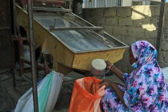woman kneeling to process rice