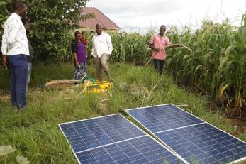 people standing near solar panels
