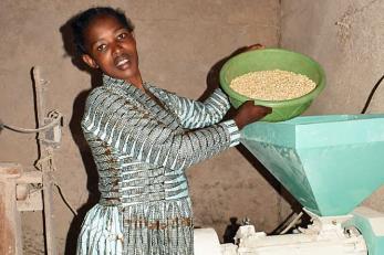 woman pouring grain in a mill