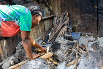 person bending over a pile of wood
