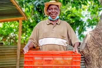 An avocado farmer holding a basket.