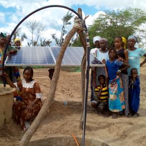 Group of people standing near a solar panel