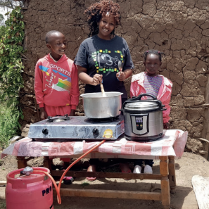 Woman and two children at table with cooking pot