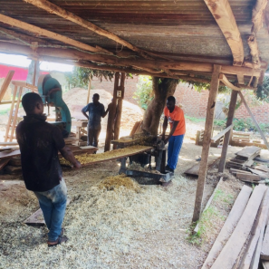 Men in shed cutting lumber