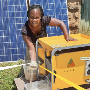 Woman holding grain from solar mill