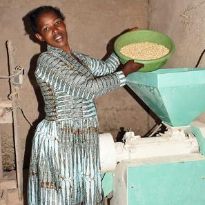 Woman pouring grain in a mill