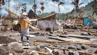 Lasiati salvages what she can find from her family’s home, after Mt. Semeru erupted in Indonesia. Prosper Global responded by providing her and her neighbors with cooking supplies.