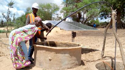 A few people drawing water from a well.