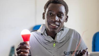Man holding led lightbulb, smiling.