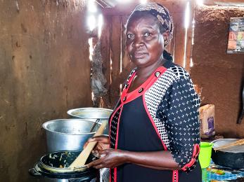 woman standing next to cooking pots