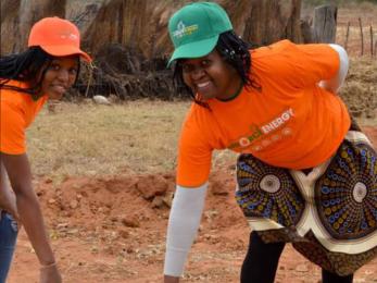 two women pulling on a well cover