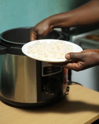 person getting food from a pot