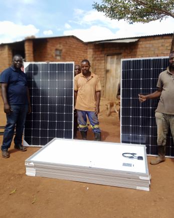 Men standing by solar panels