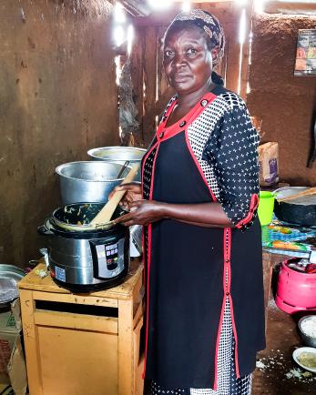 woman standing next to cooking pots