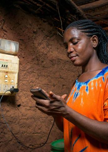 a woman holding a device by a generator