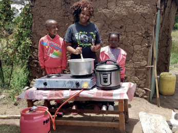 Woman and two children at table with cooking pot