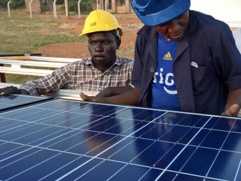 Two men constructing a solar panel