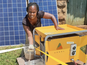 Woman holding grain from solar mill