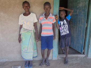 A woman and two children standing in front of an open door