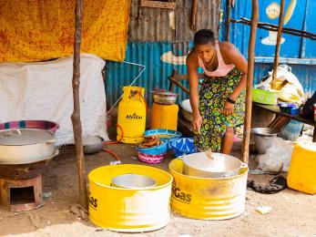 Woman bending to stir pot