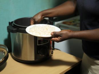 Person scooping food from pot