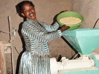 Woman pouring grain in a mill