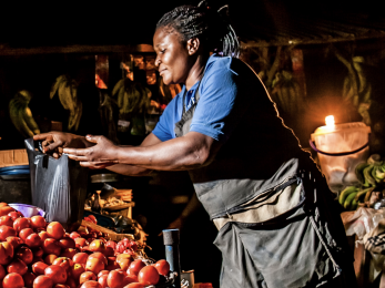 Woman holding a watering can over produce